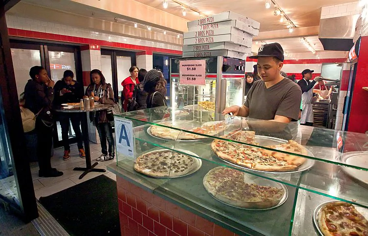 Patrons enjoys a slice or two of pizza in a local pizza restaurant in New York on Nov. 21, 2015. In an effort to cut costs and retain popular foods on the national school lunch menu, lawmakers, by virtue of tomato paste, declared pizza a vegetable. (Amal Chen/The Epoch Times)
