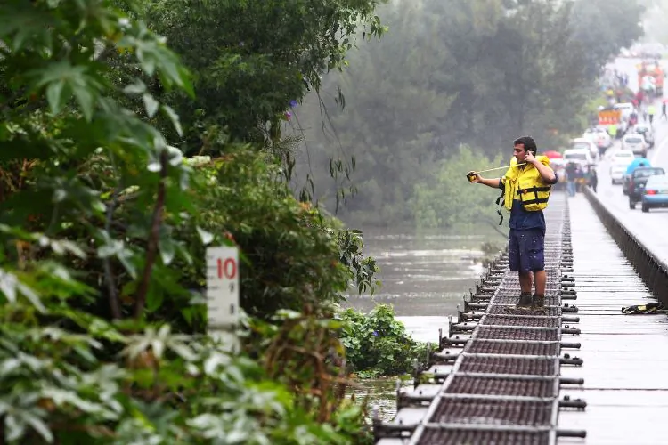 An emergency worker measures the height of the Hawkesbury River in Richmond, Australia, on March 3. (Marianna Massey/Getty Images)