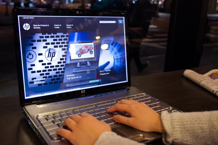 A person browses the Hewlett-Packard website while using an HP computer at a cafe in Midtown Manhattan on Feb. 23, 2015. (Benjamin Chasteen/The Epoch Times)