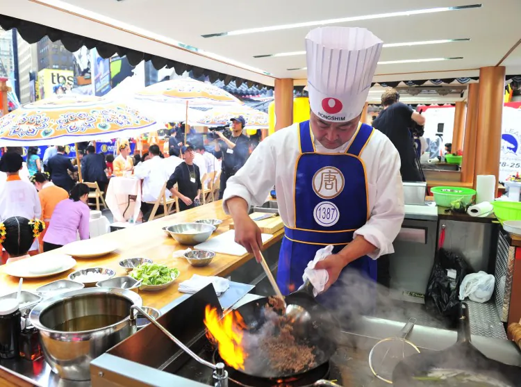A chef cooks an authentic Chinese dish in Times Square during the 2011 International Chinese Culinary Competition. This September, celebrity chefs will join Chinese chefs in firing up their woks in Times Square. (Dai Bing/The Epoch Times)