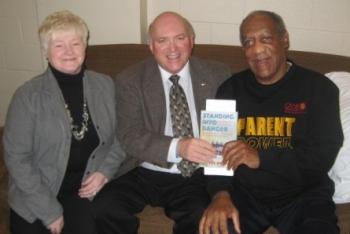 Bill Cosby invited St. Lawrence Mayor Wayde Rowsell and his wife, Carmelita, to attend his show in St. John's, Newfoundland and Labrador (NL), on Dec. 4, 2009, and also to meet him backstage prior to the show. The men are holding 'Standing into Danger,' a book by Cassie Brown about the U.S. naval disaster off the coast of NL in WWII and the dramatic rescue by the people of the nearby towns of St. Lawrence and Lawn. (Courtesy of Wayde Rowsell)