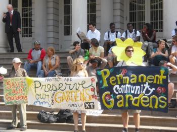 Community garden supporters hold up hand-made signs to demanding permanent status for community gardens. (Annie Wu/The Epoch Times)