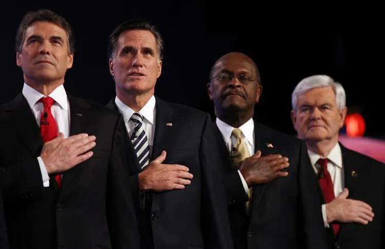 Republican presidential candidates (L-R) Texas Gov. Rick Perry, former Massachusetts Gov. Mitt Romney, former CEO of Godfather's Pizza Herman Cain and former Speaker of the House Newt Gingrich place their hands over their hearts during the national anthem prior to a debate at Constitution Hall in D.C. Nov. 22. Since Cain announced suspension of his campaign on Saturday, others in the field will await his choice for endorsement. (Win McNamee/Getty Images)
