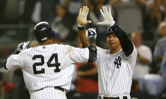 Robinson Cano (L) and Alex Rodriguez celebrate the rout Wednesday night. (Elsa/Getty Images)
