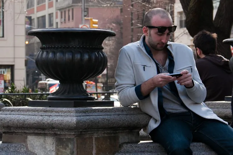A man uses his smartphone in Union Square Park in Manhattan on March 8. (Benjamin Chasteen/The Epoch Times)