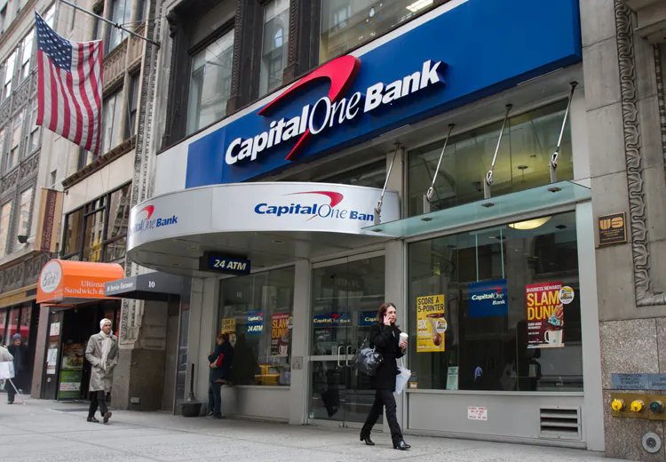 Pedestrians pass by a Capital One bank branch in Midtown Manhattan on March 16. Capital One Financial Corp. said Thursday it is selling $1.25 billion in new stock, which will help fund its growth from a regional bank to a banking giant with national presence. (Benjamin Chasteen/The Epoch Times)