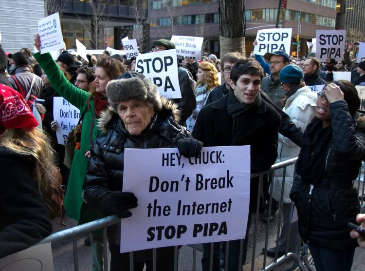 Demonstrators hold signs against proposed laws SOPA and PIPA, which will crack down on Internet piracy, in front of the Third Avenue offices of U.S. Sens. Chuck Schumer and Kirsten Gillibrand on Wednesday. (Benjamin Chasteen/The Epoch Times)