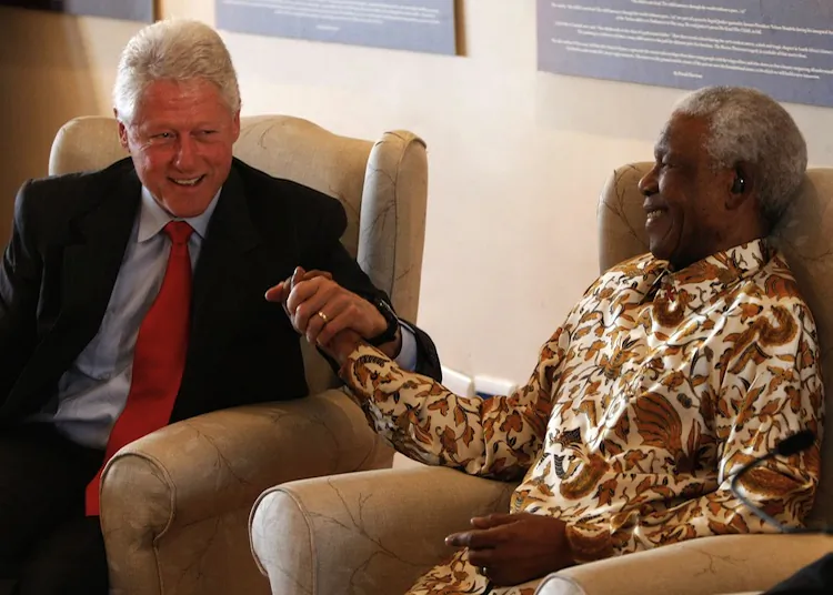 During a visit in 2007, former U.S. President Bill Clinton embraces former South African President Nelson Mandela following remarks by Clinton during a visit to the Nelson Mandela Foundation July 19, 2007 in Johannesburg. Clinton is on an eight day trip to the African continent to visit sites supported and founded by the Clinton Foundation. (Win McNamee/Getty Images for the Clinton Foundation)