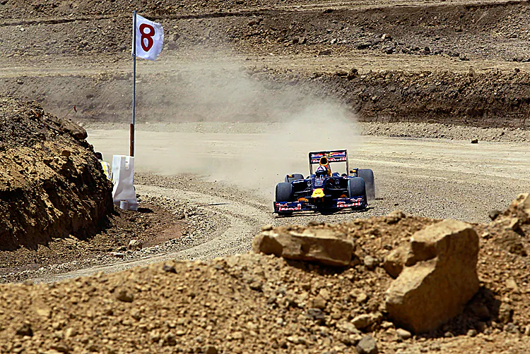 Ex-F1 driver David Coulthard pilots the Red Bull Show Car through Turn 8 at incomplete Circuit of the Americas race track on Aug. 21. If COTA and FOM cannot reach a deal, the track might never be built. (Tom Pennington/Getty Images for Red Bull)