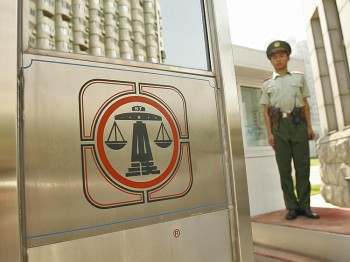 A Chinese paramilitary policeman stands guard outside Beijing's No. 2 Intermediate Court. Chinese lawyers explain that China's legal system is controlled by the Communist Party, not rule of law. (Peter Parksp/AFP/Getty Images)
