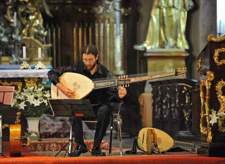 Hera singing with the theorbo during a concert in Timisoara. (Courtesy of Caius Hera)"][/caption]Romanian lute player Caius Hera’s love affair with the lute began in his room in Timisoara, Romania where he imitated the sound of the lute on his guitar. His passion led him to Basel, Switzerland and there, under the tutelage of the famous lute master Hopkinson Smith, young Hera reached the level of lute mastery that he’d always dreamed of.  Currently, Hera is working on projects with Hungarian singer Judit Andrejszki, with most of their concerts performed in Eastern Europe. In May, Hera will perform Renaissance music with Judit Andrejszki and the famous Hungarian folk singer Márta Sebestyén in Budapest. At the end of August, he is preparing a big tour in Romania, Hungary, and other nearby countries.  His First Lute  Hera had already studied classical guitar and music theory on his own in high school and only became acquainted with the lute in 2000 at the West University of Timisoara. It was then that he started experimenting with his guitar, trying to make it sound like a lute.  “I simply liked it and tried to see how it would sound on my guitar. It sounded good, but I felt that it wasn’t exactly what I wanted. Lute strings are thinner, and there are some things about the instrument’s construction [that differs]. The tensions are different. The overall sonority of the instrument is far lower than that of the guitar. The guitar sounds loud and aggressive; the lute sounds soft, very soft,” he said.  After searching for years, Hera found, in a small Romanian town, a violin maker able to make a lute for him—his first lute.  The violin maker wasn’t what Hera was prepared for. “‘What do you want, kid? You want to ruin yourself?’ was the answer to his order for a lute, Hera recalled. ‘You better go do some pop music. You want to go down the road of no return? It's like a disease, kid. When you get one lute, you'll want another, and another.’”  But Hera replied, “Give me a break, sir. Don’t depress me. I want a lute! I’ve dreamed of having my own lute for years. Now I finally found you, so please make one for me.”  “The man said, ‘Okay, kid. I’ll make a lute for you.’”  On New Year's Eve, 2004, Hera had his first lute in hand. But when he started to pluck the lute strings the next day, he was totally disappointed. The sound had no color.  He called the violin maker, “‘Sir, what have you given me here? This doesn’t sound right!’ and the man replied, ‘Kid, you don’t know what you’ve gotten yourself into. It doesn’t work that way—switching from a guitar to a lute, and that’s it? You need a specific technique. You have to study the technique of interpretation, as if you were going from the piano to the harpsichord. You must realize this is another tool. You must take master classes.’”  Unwilling to renounce his dream of mastering the lute, Hera went to Lake Balaton in Hungary. There was a music festival that year and the great lute master, Hopkinson Smith, was invited. Hera met him and arranged some master classes with him and then he said to himself, “This is good! I’m finally on the right track.” But he wanted more. He wanted to sit there and study everything from the beginning. Hera remembers: “Hopkinson said, ‘No problem, you can find me in Basel.’”  With extraordinary guts, Hera took all of his savings, booked a train ticket and—bang!—he went to Basel. He studied with Hopkinson Smith for two years. And, although he wondered about it, because it was enormously expensive, he ended up studying with the greatest and the most famous musicians of early music—with Crawford Young, studying Medieval to early Renaissance lute playing, and with British lutenist Anthony Rooley.  Hera went to Basel with one lute, but he returned with many other old instruments. In addition to the Renaissance lute, he mastered the vihuela da mano, a baroque lute with 13 strings; a theorbo, or long-necked lute; an oud, a pear-shaped string instrument; a Baroque guitar; a Renaissance lute and many other instruments with six, seven, and ten strings.  “It was just as the violin maker said, ‘That thing will get you, kid. You won’t be able to stop. You'll always want new instruments and you’re always going to call me and tell me that you need a tool shank with this or that, or another with—I don’t know what—and in the end you will end up with four or five instruments that are the same, with only small differences between them.’”  [video w="590
