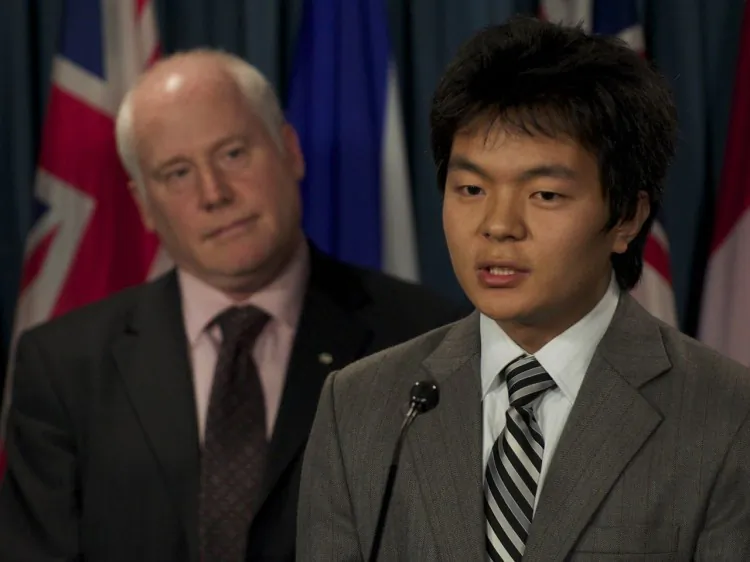 Lucy Zhou, with the Falun Dafa Association of Canada, talks to reporters as Cheuk Kwan of Toronto Association for Democracy in China looks on. (Matthew Little/The Epoch Times)