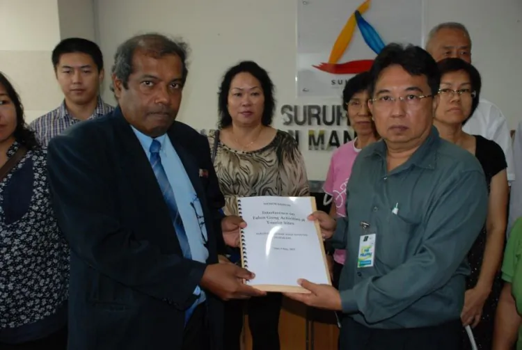 Muhammad Sha’ani (L), commissioner of SUHAKAM, accepted a memorandum on May 9 from Raymond Ng (R), spokesperson for Falun Gong practitioners in Malaysia.