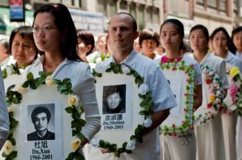 People hold pictures of those who have lost their lives to the Chinese Communist Party for practicing Falun Gong. (Joshua Philipp/The Epoch Times)