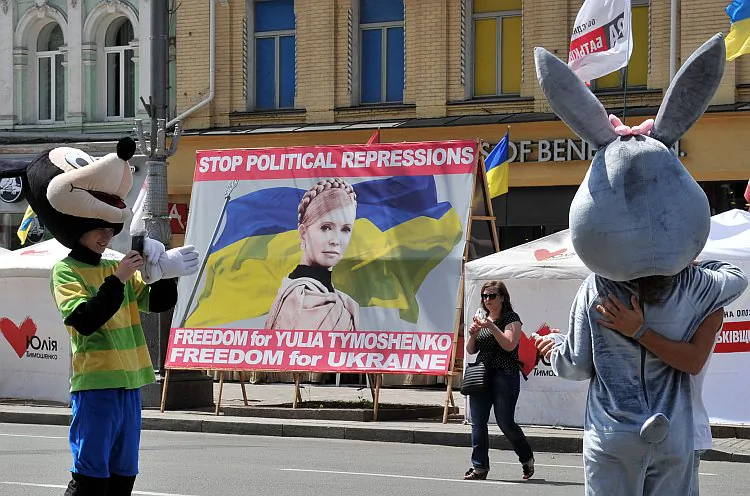 Soccer fans pose next to a banner calling for the release of Ukraine's jailed ex-Prime Minister Yulia Tymoshenko in front of the Euro 2012 fan zone in Kyiv on June 8, a few hours before the opening game. (Genya Savilov/AFP/GettyImages)