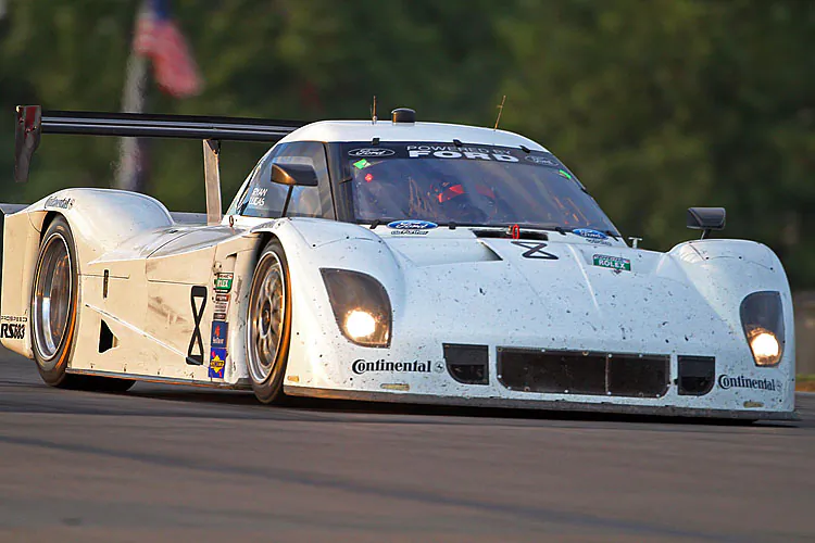 The points-leading FXDD Ferrari tangles with the Stevenson Camaro in Turn One on the first lap of the race. (Grand-am.com)