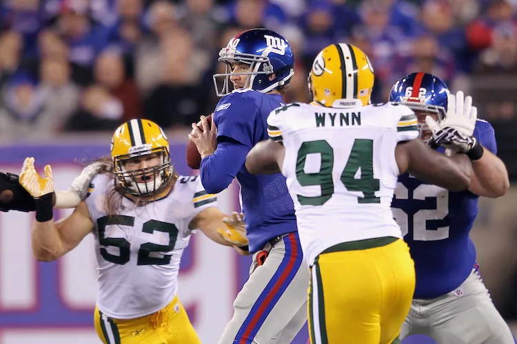 (Eli Manning (with ball) and the Giants fared well against Green Bay the first time around, falling 38—35. (Nick Laham/Getty Images)