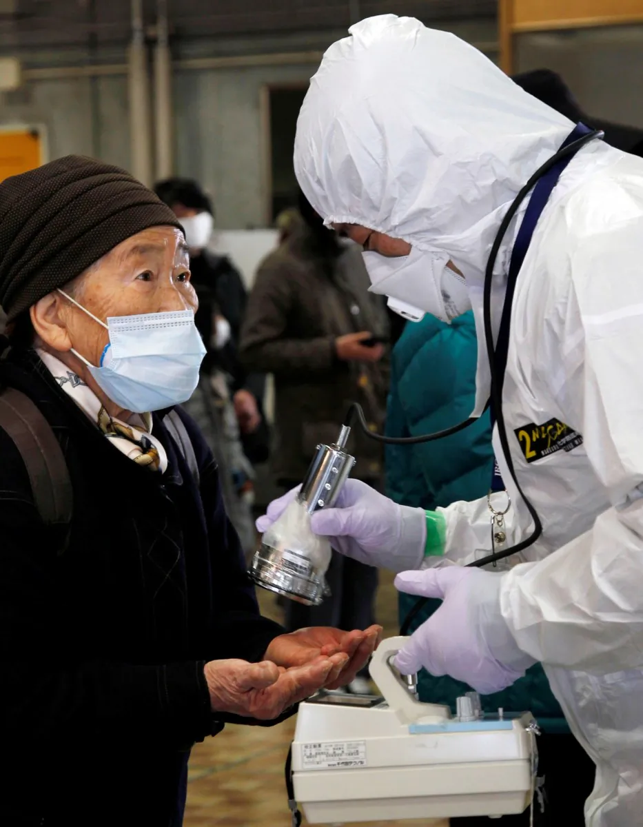 An official measures radiation levels in an elderly woman (L) at an evacuation center in Koriyama city in Fukushima prefecture, about 35 miles from the crisis-hit Fukushima Nuclear Power Plant, on March 16, 2011. (Ken Shimizu/AFP/Getty Images)