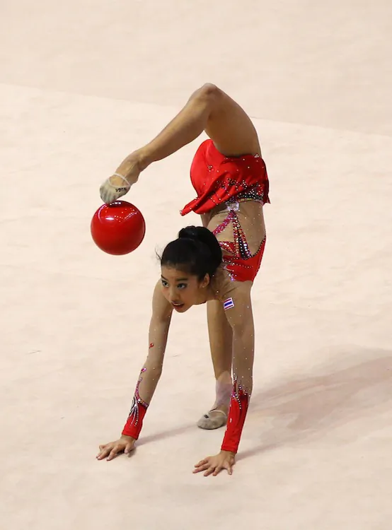 Anyavarin Supateeralert of Thailand competes in the women's rhythmic gymnastics on day eight of the 2011 Southeast Asian Games on Nov. 18 in Palembang, Sumatra, Indonesia. Rhythmic gymnasts have strength, power, flexibility, agility, dexterity, and endurance. Participants will master the use of a rope, hoop, clubs, ribbon, or (as shown here) a ball. The ball is thrown and caught, balanced on their hands, or rolled on the floor to program music, displaying both grace and elegance. There are also group performances where teams of five use two apparatus, working together as a unit. The 1984 games in Los Angeles was the first time rhythmic gymnastics was added as a medal sport in the Olympics.(Photo by Matt King/Getty Images)