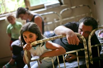Displaced Georgians from the breakaway province of South Ossetia sit on a bed in a refugee shelter in Tbilisi, Georgia on Aug. 17, 2008.  (Uriel Sinai/Getty Images)