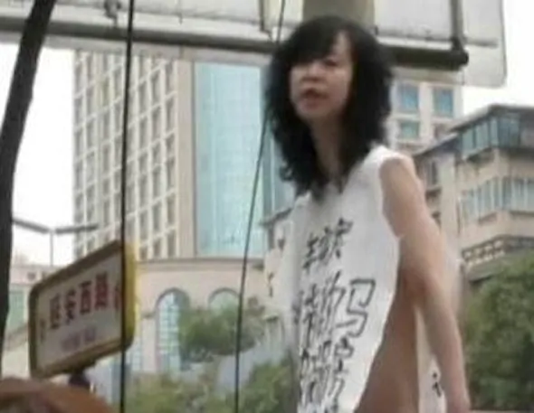 A naked woman with a piece of white cloth hanging off of her shoulders stood on a garbage bin outside the Supreme Court of Guizhou Province. (the original video with Chinese text is two minutes, 35 seconds; a shorter, 1 minute 38 second version has been uploaded with this article)