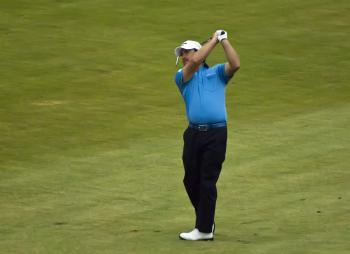 Graeme McDowell hits his approach shot to the ninth green on Sunday. He parred the hole and finished the first nine holes at 3-under par, gaining 3 strokes on Tiger Woods, his playing partner. (Dan Sanchez/The Epoch Times) Graeme McDowell hits his approach shot to the ninth green on Sunday. He parred the hole and finished the first nine holes at 3-under par, gaining 3 strokes on Tiger Woods, his playing partner. (Dan Sanchez/The Epoch Times)