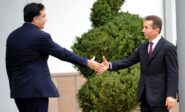 Georgia's President Mikheil Saakashvili (L) shakes hands with the leader of Georgian Dream opposition coalition Bidzina Ivanishvili (R) as they meet in Tbilisi, on Oct. 9. Ivanishvili’s coalition defeated Saakashvili's ruling party at parliamentary polls last week. (Vano Shlamov/AFP/GettyImages)