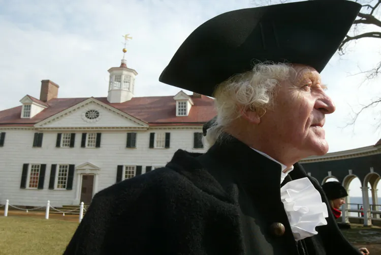 Dressed as founding father George Washington, William Sommerfield waits to greet visitors outside a mansion in Mount Vernon, Va. According to historians, Washington’s importance has waned in recent decades, but a library being built at Mount Vernon aims to spark new interest. (Alex Wong/Getty Images)