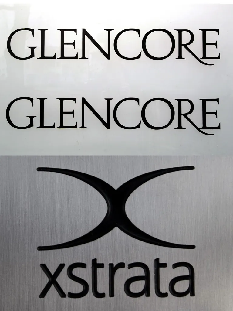 The composite photo shows the logos of commodities giants Glencore and Xstrata. The Anglo-Swiss companies said on Oct. 1 that they had agreed on revised terms of their merger to create a massive mining company with combined revenues exceeding $220 billion. (Fabrice Coffrini/AFP/GettyImages)