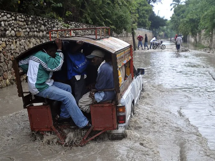 Haitians travel a flooded street in the aftermath of Hurricane Sandy Oct. 25, in Port-au-Prince, Haiti. (Thony Belizaire/AFP/Getty Images)