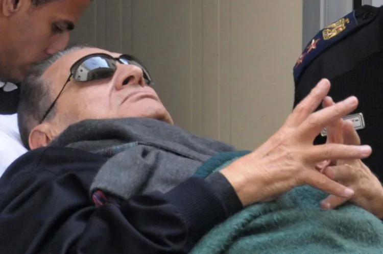 Former Egyptian President Hosni Mubarak lies on a stretcher as he leaves court. (AFP/Getty Images)