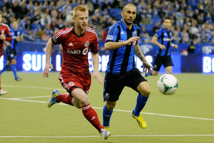 Toronto FC’s Richard Eckersley (L) and Montreal Impact’s Marco Di Vaio compete for the ball in MLS action at Montreal’s Olympic Stadium on Mar. 16. The Impact won their home opener against their Canadian rivals. (Richard Wolowicz/Getty Images)