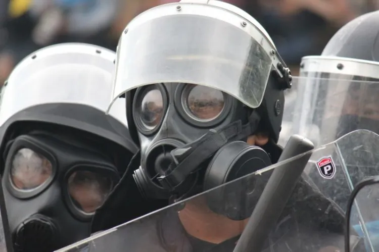 A supporter of the royalist group Pitak Siam has her eyes washed after Thai police fired tear gas at an area around the group’s rally site in Bangkok on Saturday, Nov. 24. (Cameron McKinley/The Epoch Times)