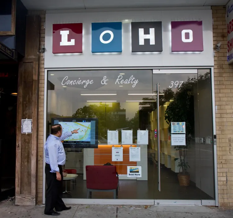 Vernon Jones, CEO of LOH, demonstrates to guests his company’s new interactive touch screen on June 28. The touch screen is designed for real estate companies or brokers to install in storefront windows in the Lower East Side of Manhattan. (Benjamin Chasteen/The Epoch Times)