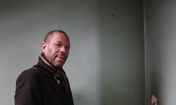 Nehemiah Bey of the Northwest Bronx Community and Clergy Coalition stands in the hallway of a grossly neglected residential building in the Bronx in this file photo. (Tara MacIsaac/The Epoch Times)