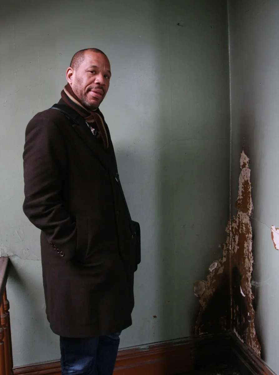 Nehemiah Bey of the Northwest Bronx Community and Clergy Coalition stands in the hallway of a grossly neglected residential building in the Bronx in this file photo. (Tara MacIsaac/The Epoch Times)
