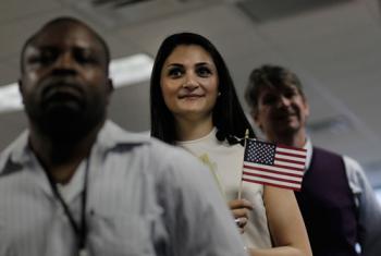 PRIDE OF CITIZENSHIP: Iveta Stephanopolous (C), originally from Armenia, holds an American flag during a naturalization ceremony at a U.S. Citizenship and Immigration Services office May 14, 2010 in New York City.  (Chris Hondros/Getty Images)