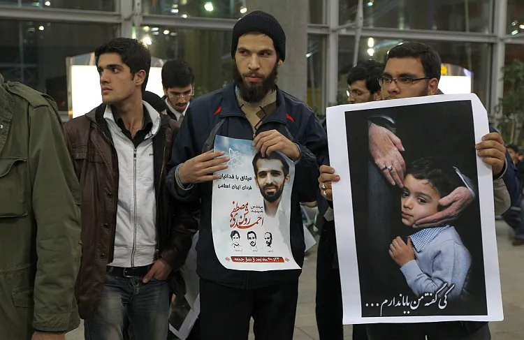 Iranian students hold photo of assassinated nuclear scientist Mostafa Ahmadi-Roshan and son as they protest the arrival of International Atomic Energy Agency inspectors at the airport in Tehran on Jan. 29. (Atta Kenare/AFP/Getty Images)