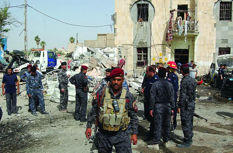 Iraqi security gather at the scene of a suicide attack car bomb in front of a police station in Basra on June 13 (-/AFP/Getty Images)