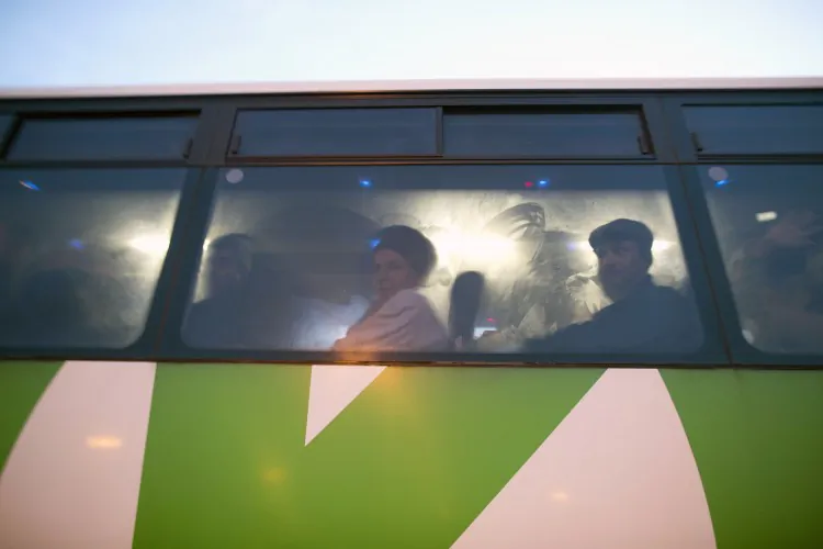 Palestinians sit in a bus as a new line is made available by Israel to take Palestinian worker from the Israeli army crossing Eyal into the Israeli city Tel Aviv, on Mar. 4 2013. Thousands of Palestinians enter Israel to work every day after receiving permits, many of them in private vans. (Menahem Kahana/AFP/Getty Images)