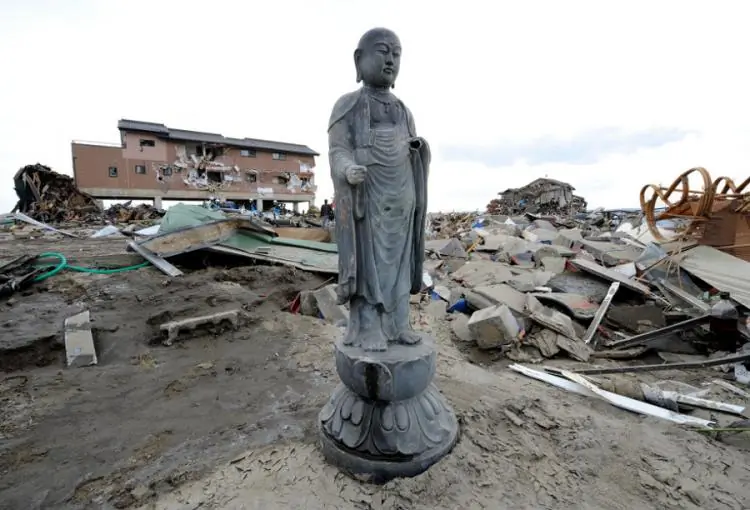 ABOVE AND BEYOND: A Buddha statue sits amid the rubble with skeletons, which were washed up from a nearby graveyard by the deadly tsunamis of December 26 in the southwestern coastal town of Kahawa in Sri Lanka, Jan. 2, 2005. (Raveendran/AFP/Getty Images)