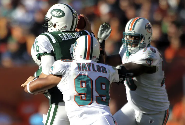 Mark Sanchez gets drilled by former-Jet Jason Taylor, in Taylor's final game as a pro. Sanchez threw three interceptions on the day as the Jets lost 19–17 at Miami. (Marc Serota/Getty Images)