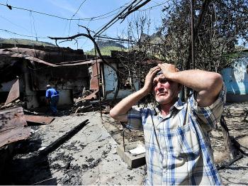 An ethnic Uzbek holds his head in his hands as he stands beside the wreckage of his burned out home in Osh on June 14, 2010. Deadly gun battles raged in the Kyrgyzstan city of Osh where bodies littered the streets as ethnic violence escalated and Uzbekistan raced to cope with a massive refugee influx. (Victor Drachev/AFP/Getty Images)