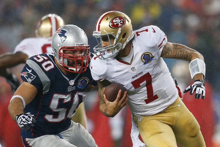 Colin Kaepernick (R) of the San Francisco 49ers evades Rob Ninkovich of the New England Patriots on Sunday, Dec. 16, 2012 at Gillette Stadium in Foxborough, Mass. (Jim Rogash/Getty Images)