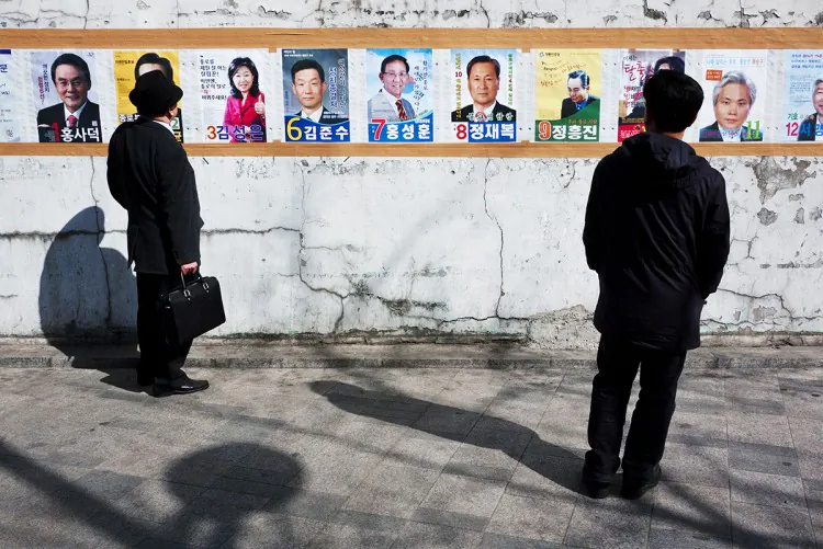 South Korean voters view promotional posters of candidates for the General Assembly election on April 11. (Jarrod Hall/The Epoch Times)