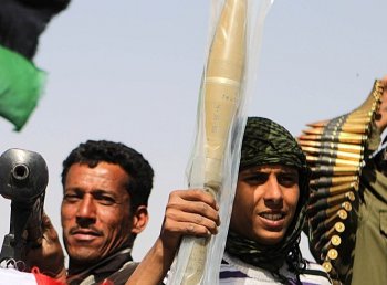 MADE IN CHINA? Libyan rebels raise a brand new rocket propelled grenade and ammunition they took from abandoned pro-Gadhafi forces ammunition stocks on March 27. (PATRICK BAZ/AFP/Getty Images)
