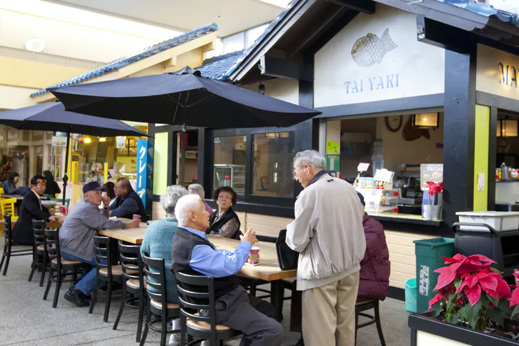 People eat and chat at the Japan Center in San Francisco’s Japantown on Feb. 27, 2013. The neighborhood remains a center for people with Japanese ancestry to socialize and work in, even if many no longer live there. (Alex Ma/The Epoch Times)