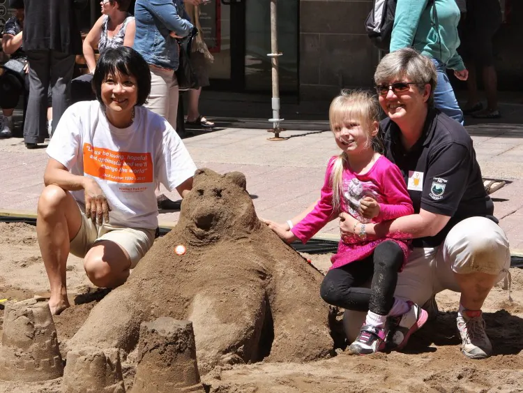 Schoolchildren build sandcastles in the world’s largest sandbox on Sparks St. in downtown Ottawa at an event to raise awareness about The Sandbox Project on June 13. (NTD)