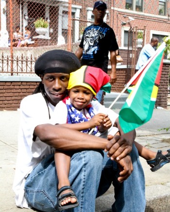 RESERVING HERITAGE: Father and son celebrate their roots at the West Indian American Day Carnival and Parade of Bands in Crown Heights, Brooklyn on Monday. (Tara MacIsaac/The Epoch Times) RESERVING HERITAGE: Father and son celebrate their roots at the West Indian American Day Carnival and Parade of Bands in Crown Heights, Brooklyn on Monday. (Tara MacIsaac/The Epoch Times)