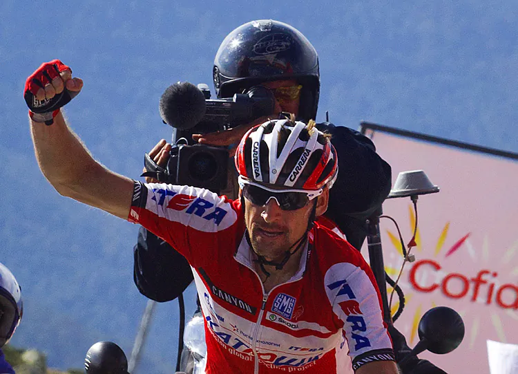 An exhausted Alberto Contador is pushed by supporters at the finish line after the climb to Bola del Mundo. (Jaime Reina/AFP/GettyImages)